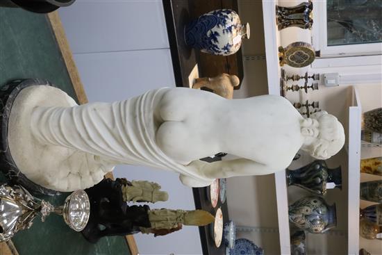 A Victorian style carved white marble figure of a woman pulling on her stocking, H.31in.
